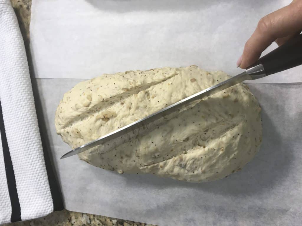 cutting top of loaf of bread dough